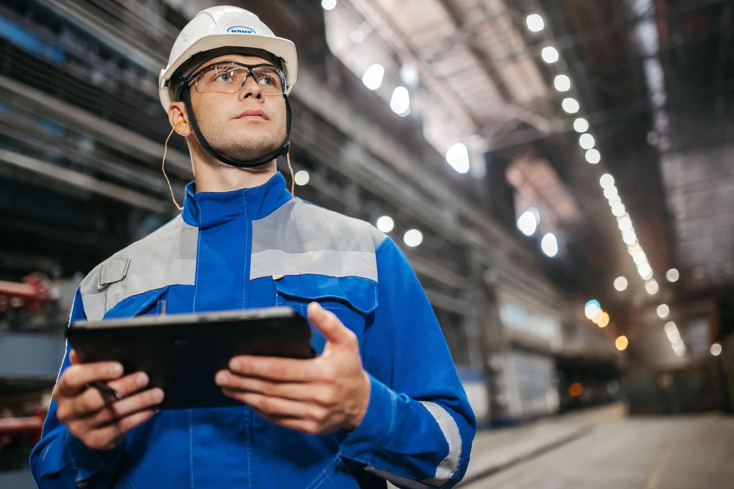 Profesional en una instalación industrial utilizando una tablet durante una inspección