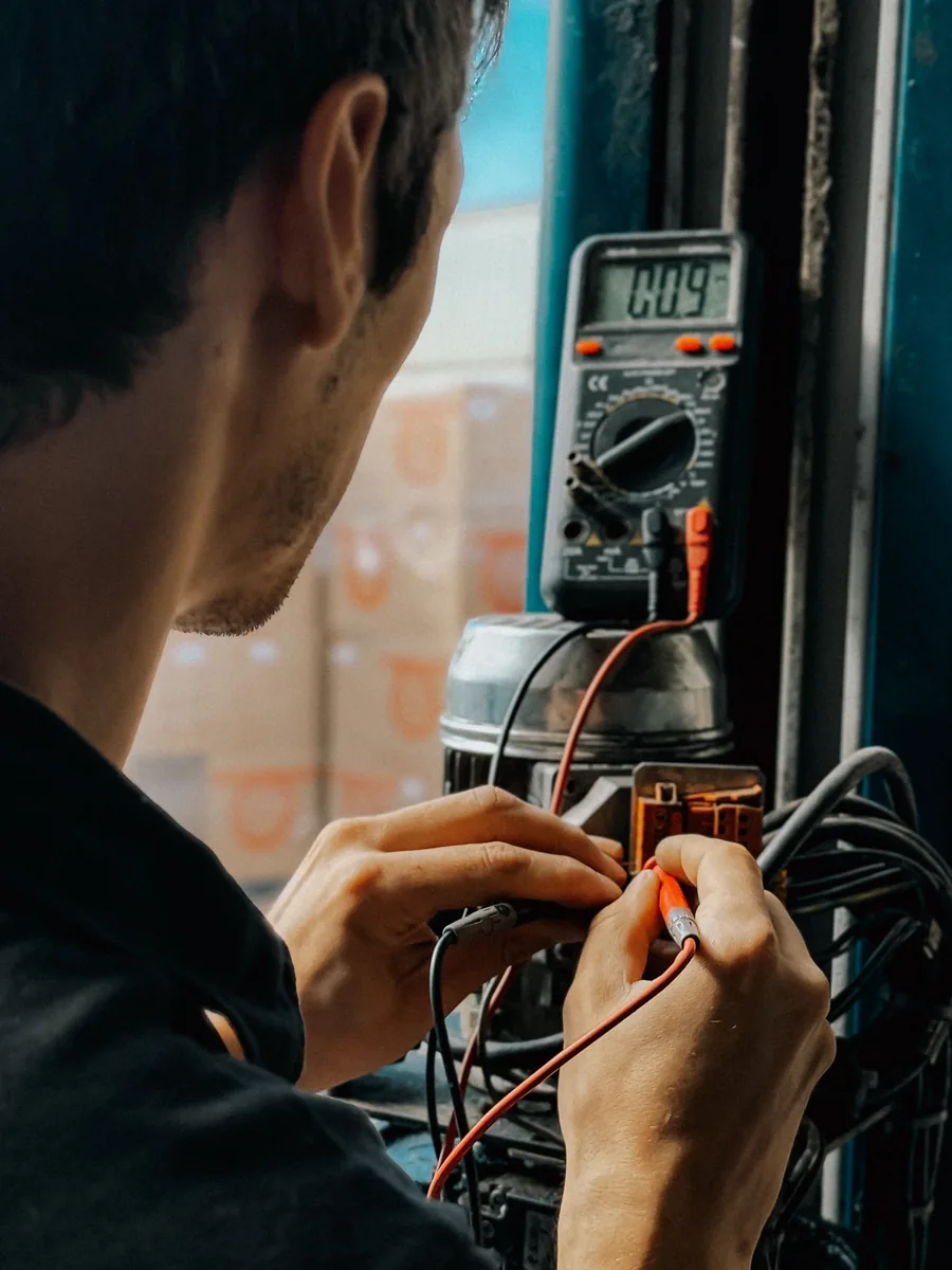 Técnico utilizando un instrumento de medición eléctrica